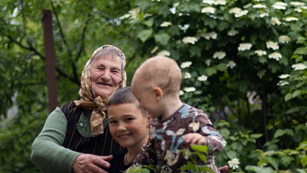 a woman and two children standing in a garden